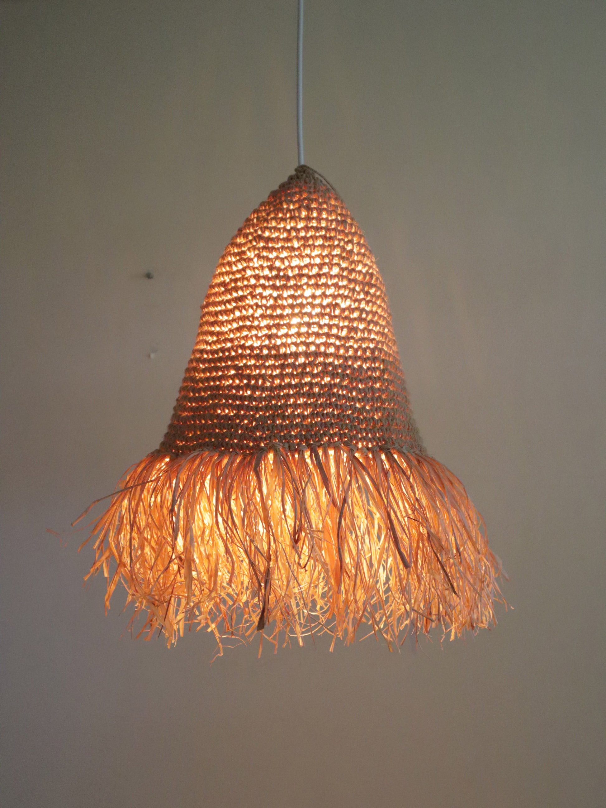 Woven pendant light with a textured design on a plain background