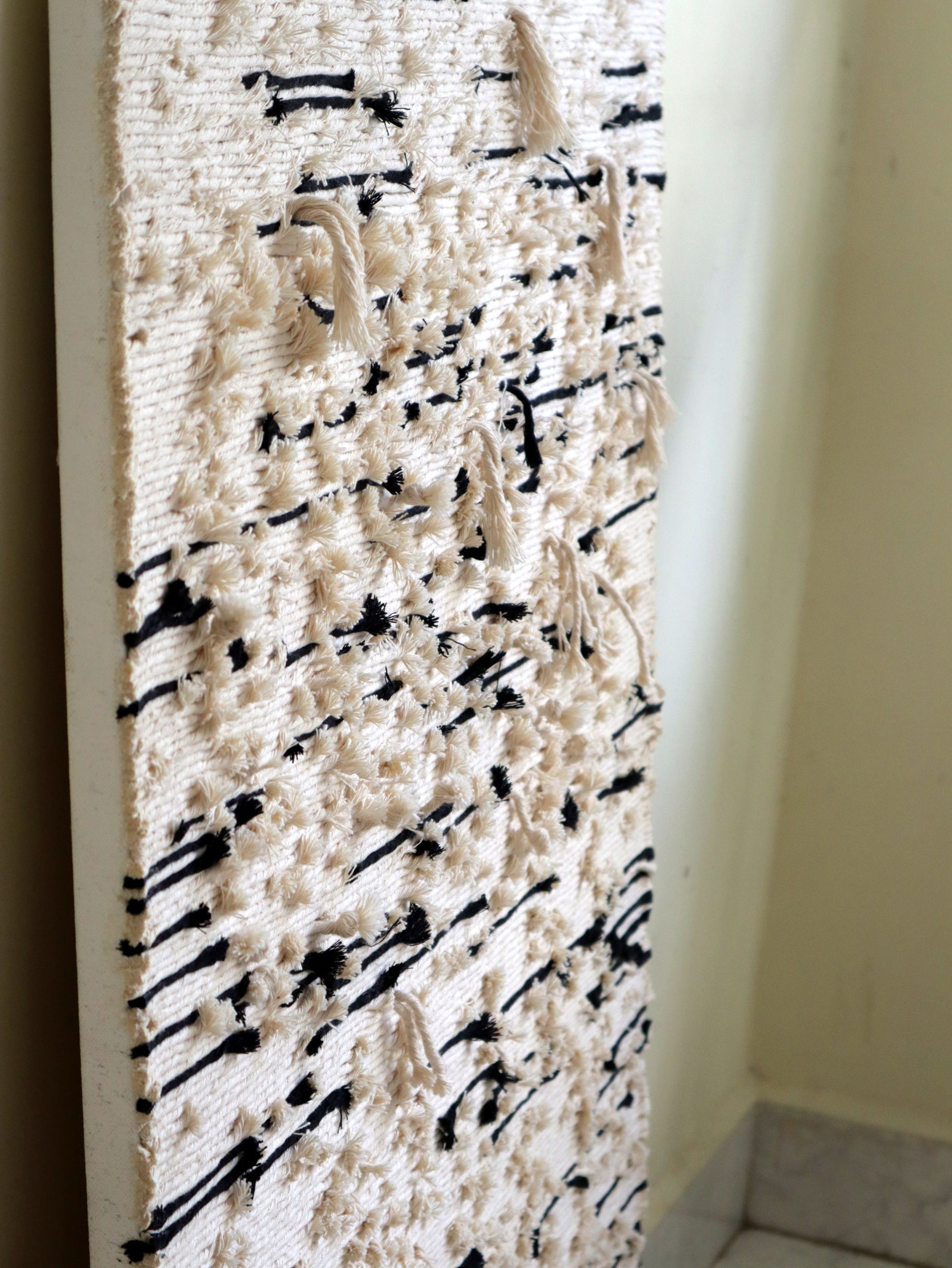 Textile Art with black abstract patterns on a white background